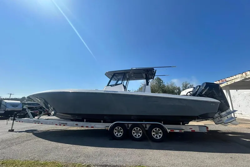 The Image of 2023 Fountain 38TE CC boat on trailer, parked outdoors under clear blue sky. - 0
