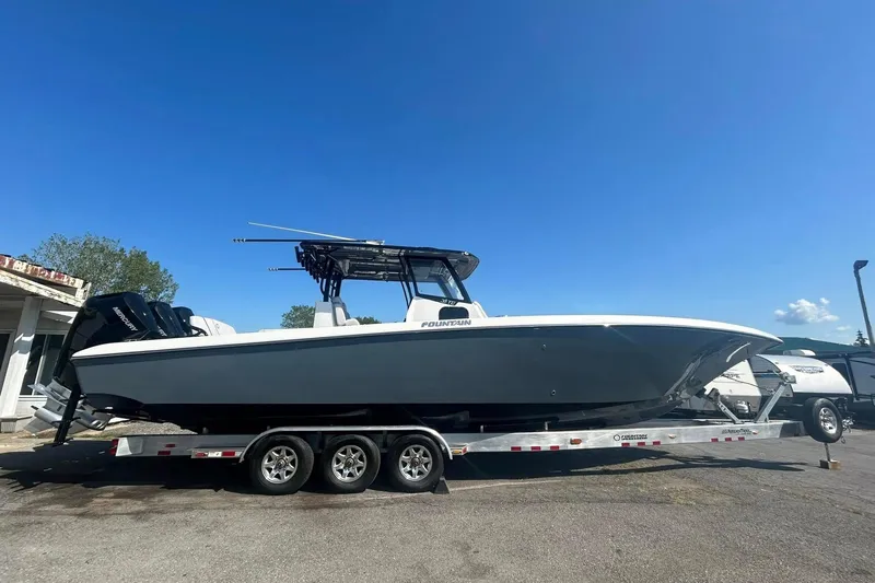 Slide: The Image of 2023 Fountain 38TE CC boat interior with modern helm and seating under clear blue sky. - 10