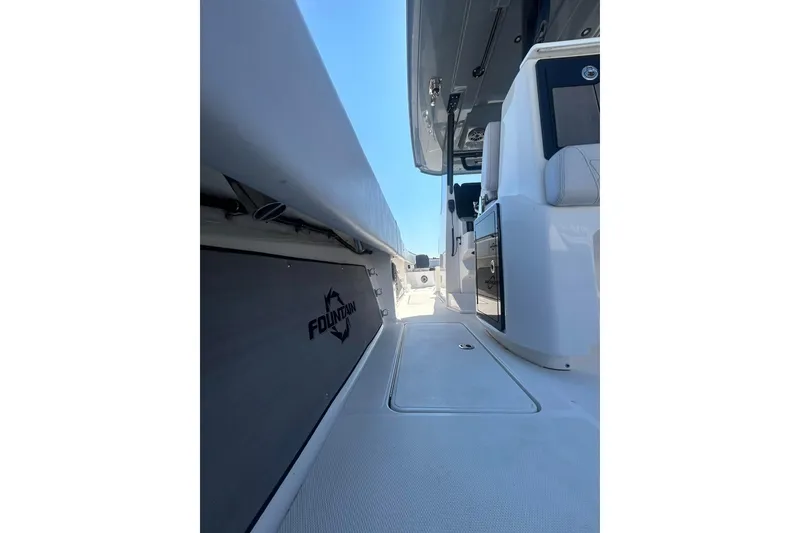 Slide: The Image of 2023 Fountain 38TE CC boat with spacious deck and seating, parked outdoors. - 14