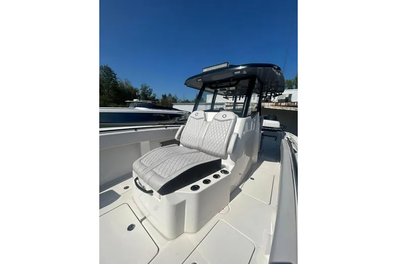 Slide: The Image of 2023 Fountain 38TE CC boat on trailer, parked outdoors near RV. - 4