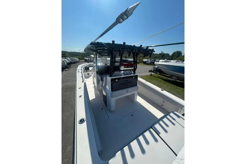 Slide: The Image of 2023 Fountain 38TE CC boat interior with seating and rod holders under clear blue sky. - 7