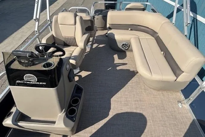 Slide: The Image of 2024 Sun Tracker Bass Buggy 18 DLX pontoon boat with beige seating and steering console. - 16