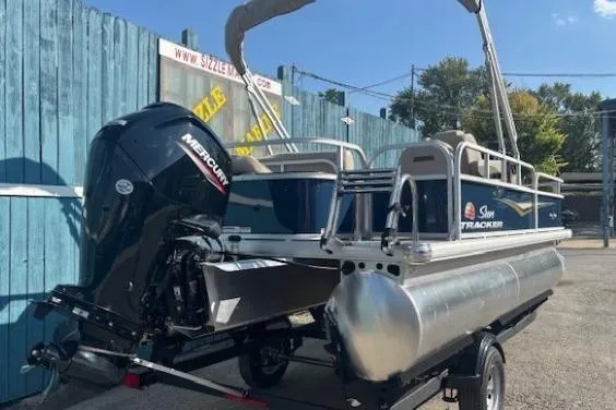 Slide: The Image of 2024 Sun Tracker Bass Buggy 18 DLX pontoon boat with Mercury outboard motor. - 2