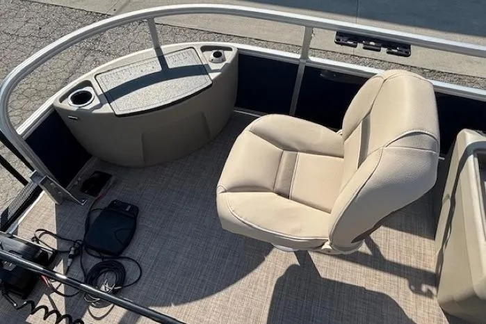 Slide: The Image of 2024 Sun Tracker Bass Buggy 18 DLX boat interior with beige seating and control panel. - 8