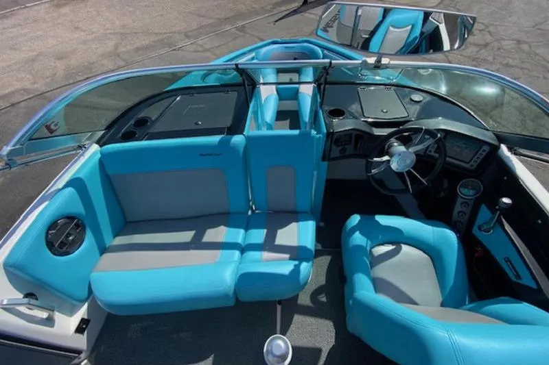 Slide: The Image of 2018 MasterCraft ProStar boat interior with blue and gray seating, steering wheel, and dashboard. - 6
