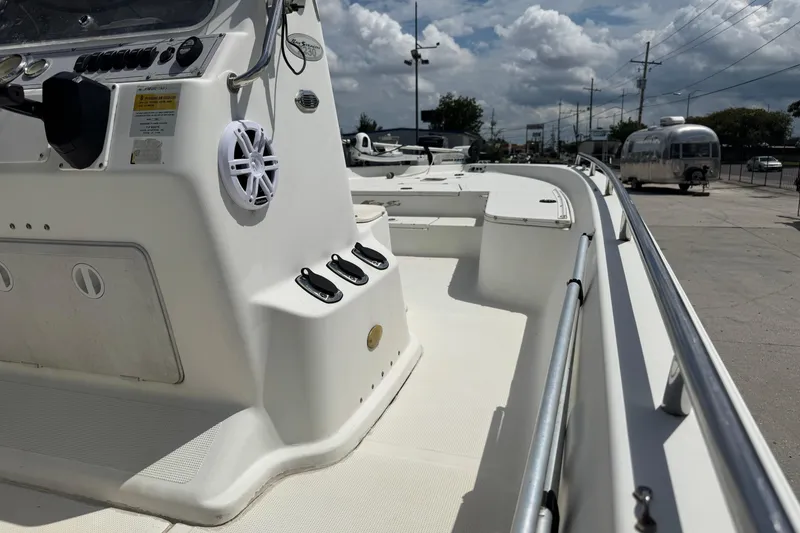 Slide: The Image of 2005 Bay Stealth 2230 boat interior with control panel and seating, under a cloudy sky. - 14