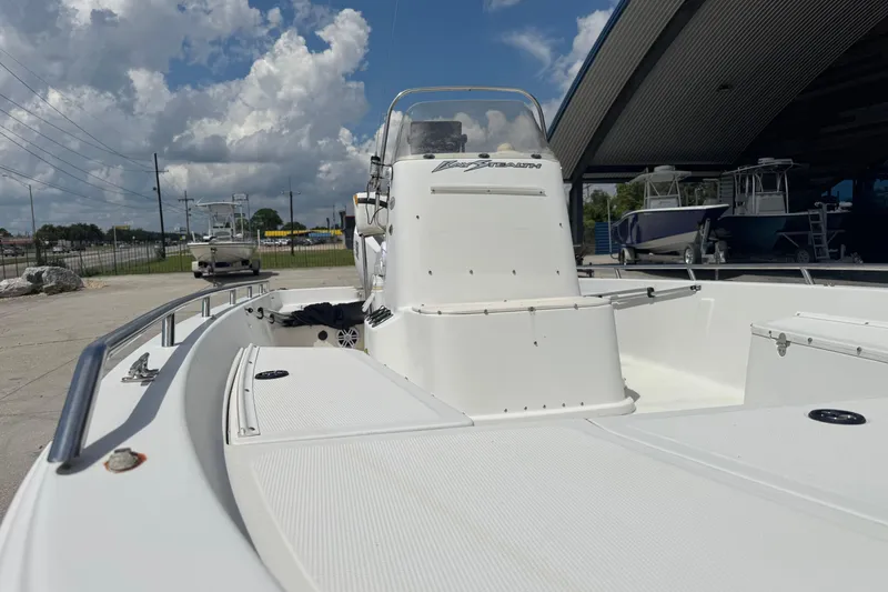 Slide: The Image of 2005 Bay Stealth 2230 boat with open deck, parked under a cloudy sky. - 16