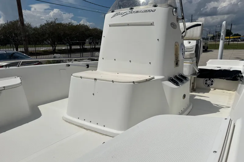 Slide: The Image of 2005 Bay Stealth 2230 boat interior with seating and console under a cloudy sky. - 20