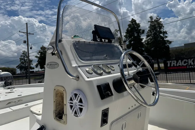 Slide: The Image of 2005 Bay Stealth 2230 boat console with steering wheel and gauges under a cloudy sky. - 21