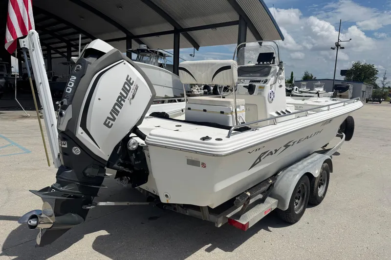 Slide: The Image of 2005 Bay Stealth 2230 boat with Evinrude motor on a trailer, parked outdoors. - 7