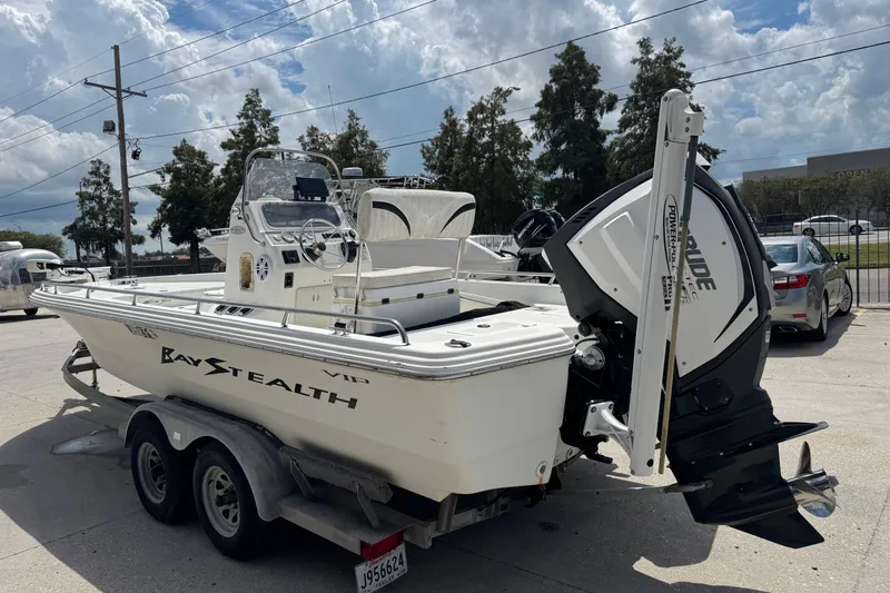Slide: The Image of 2005 Bay Stealth 2230 boat on trailer, parked outdoors under cloudy sky. - 9