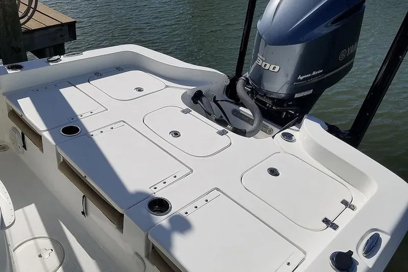 Slide: The Image of 2019 Sea Hunt BX 25 FS boat deck with Yamaha 300 engine, docked by water. - 2