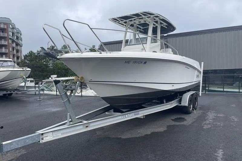 Slide: The Image of 2012 Boston Whaler 250 Outrage on trailer, parked outdoors near buildings. - 2