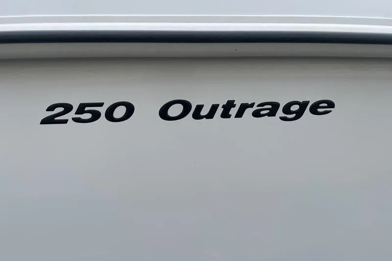 Slide: The Image of 2012 Boston Whaler 250 Outrage boat nameplate on white hull. - 4