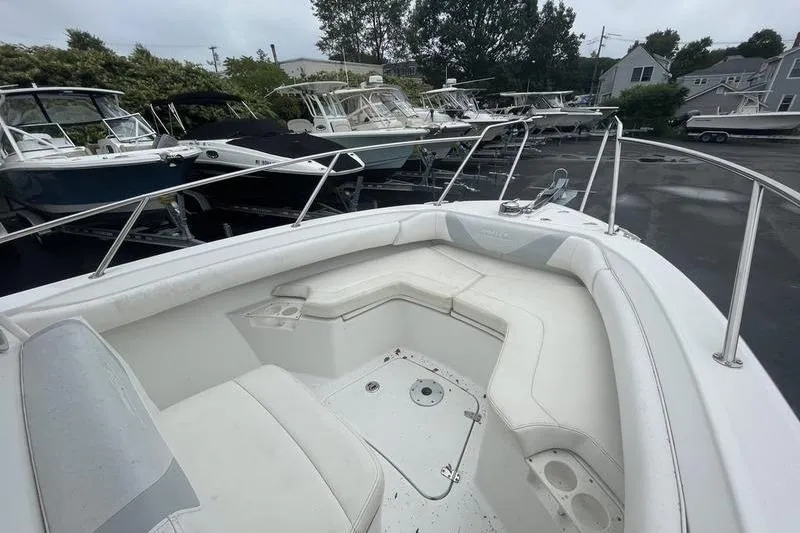 Slide: The Image of 2012 Boston Whaler 250 Outrage boat with spacious seating, docked among other boats. - 6