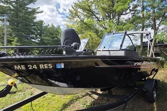 Slide: The Image of 2022 Tracker Pro Guide V-175 WT boat on trailer, surrounded by trees and blue sky. - 4