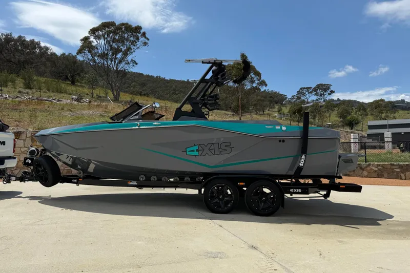 Slide: The Image of 2022 Axis T220 boat on trailer, parked outdoors under clear blue sky. - 3