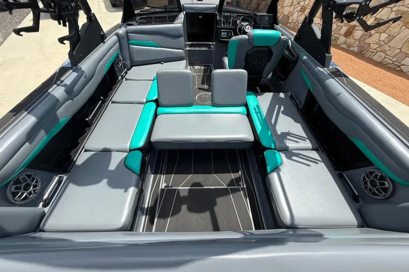 Slide: The Image of 2022 Axis T220 boat interior with gray and teal seating, modern design, and integrated speakers. - 5