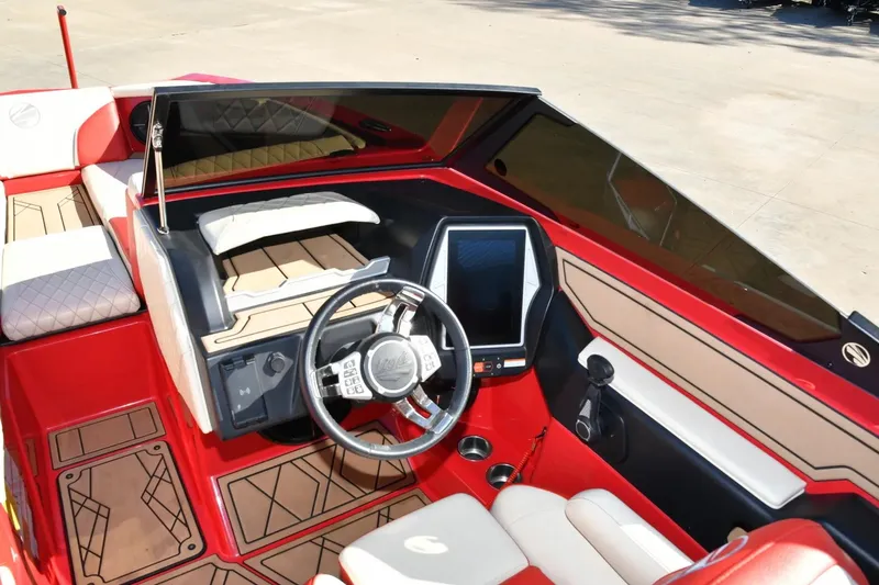 Slide: The Image of 2022 Tigé 24RZX boat interior with red and beige seating, modern dashboard, and steering wheel. - 13