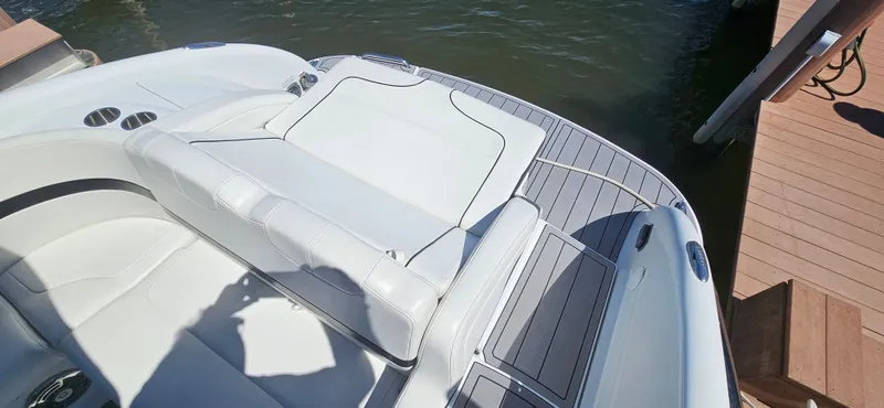 Slide: The Image of 2011 Formula 310 Bowrider boat with white seating and deck, docked by the water. - 13