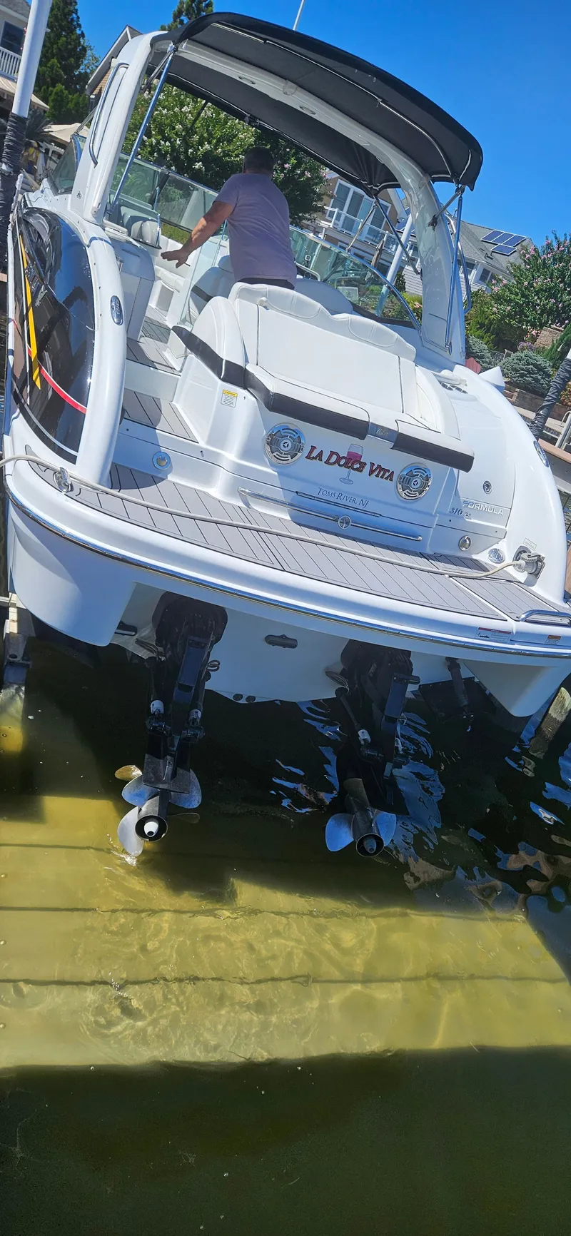 Slide: The Image of 2011 Formula 310 Bowrider boat docked, rear view with dual propellers visible. - 14