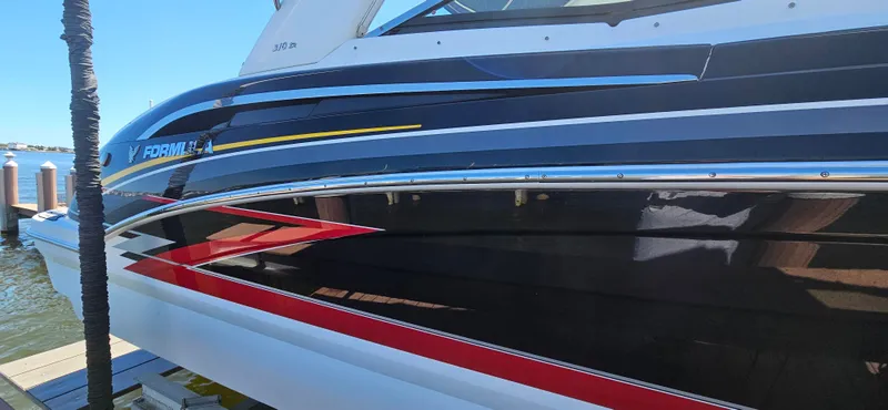 Slide: The Image of 2011 Formula 310 Bowrider boat docked, showcasing sleek design and vibrant colors. - 18