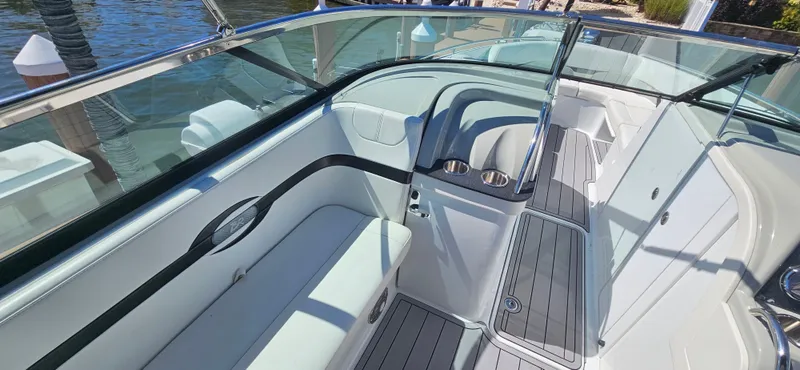 Slide: The Image of 2011 Formula 310 Bowrider interior with seating and cup holders, docked by the water. - 4