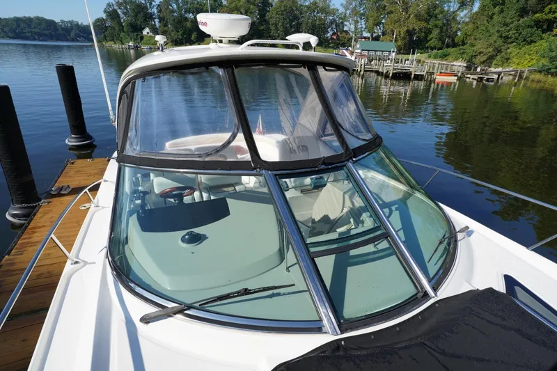 Slide: The Image of 2010 Sea Ray 370 Sundancer docked on a serene lake with lush greenery. - 15