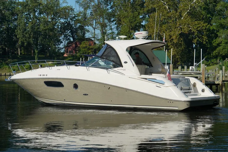 Slide: The Image of 2010 Sea Ray 370 Sundancer yacht on calm water, surrounded by trees. - 2