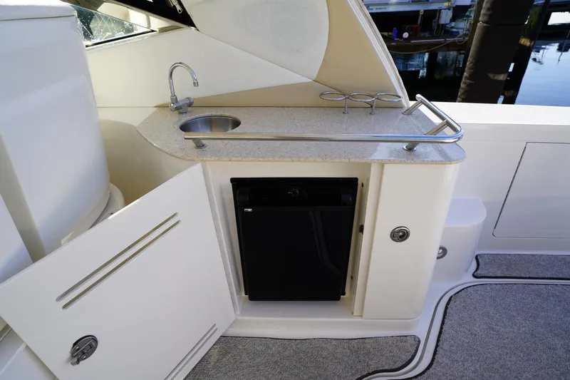 Slide: The Image of 2010 Sea Ray 370 Sundancer yacht kitchenette with sink, mini-fridge, and storage. - 38