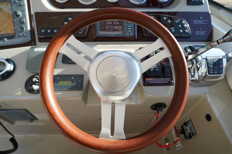 Slide: The Image of Steering wheel of 2010 Sea Ray 370 Sundancer boat, featuring wood and metal design. - 43