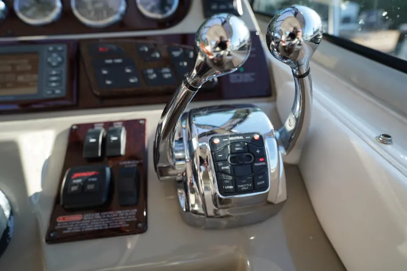Slide: The Image of Control panel of a 2010 Sea Ray 370 Sundancer boat with chrome levers and switches. - 48
