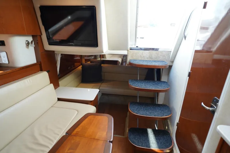 Slide: The Image of Interior of 2010 Sea Ray 370 Sundancer yacht with seating, TV, and carpeted stairs. - 52