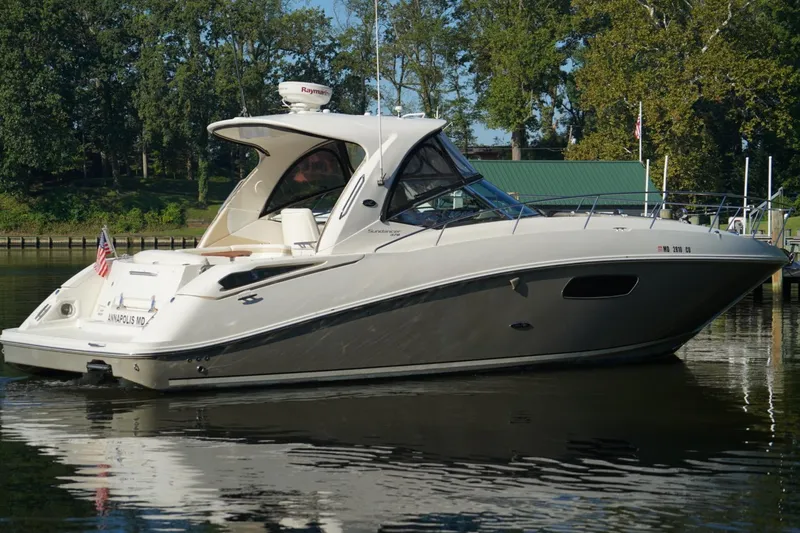 Slide: The Image of 2010 Sea Ray 370 Sundancer yacht docked on calm water, surrounded by trees. - 6