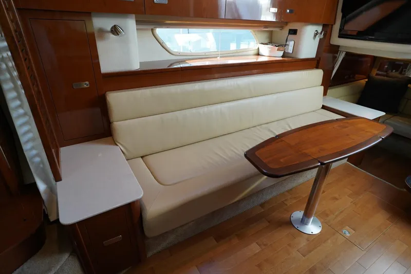 Slide: The Image of Luxurious interior of 2010 Sea Ray 370 Sundancer with cream sofa and wooden table. - 61