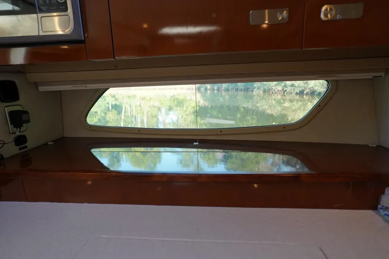 Slide: The Image of Interior view of 2010 Sea Ray 370 Sundancer with window and wooden cabinetry. - 65