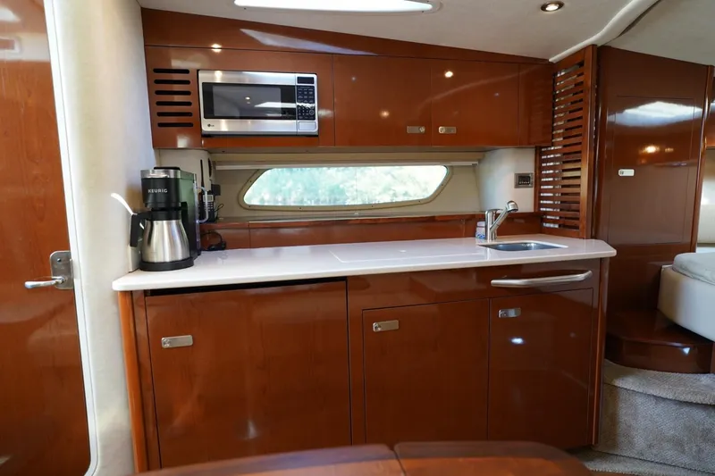 Slide: The Image of Luxurious 2010 Sea Ray 370 Sundancer yacht kitchen with modern amenities and sleek wood cabinetry. - 69