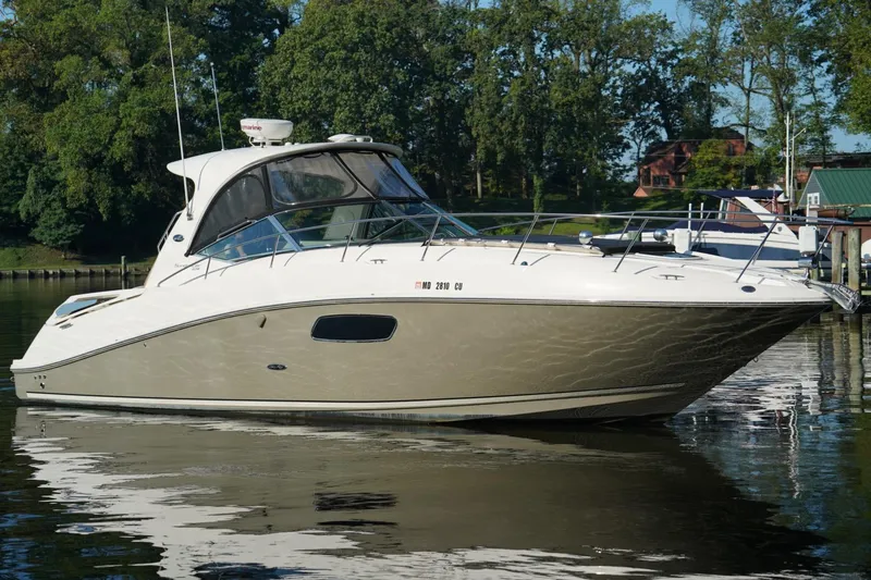 Slide: The Image of 2010 Sea Ray 370 Sundancer yacht docked on calm water, surrounded by trees. - 7