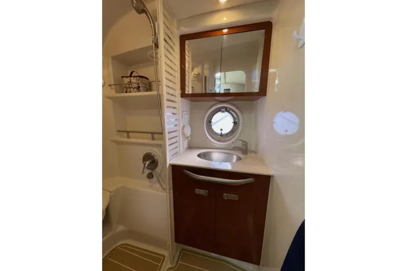 Slide: The Image of 2010 Sea Ray 370 Sundancer bathroom with sink, toilet, and porthole window. - 71