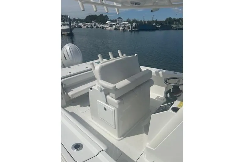 Slide: The Image of 2025 Parker 2600 Center Console boat interior with seating and steering, docked at marina. - 13