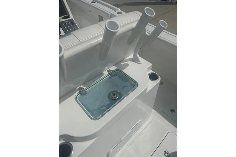 Slide: The Image of 2025 Parker 2600 Center Console boat interior with rod holders and storage compartment. - 16