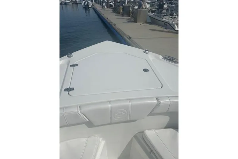 Slide: The Image of 2025 Parker 2600 Center Console boat docked at marina, featuring sleek design and storage hatch. - 6