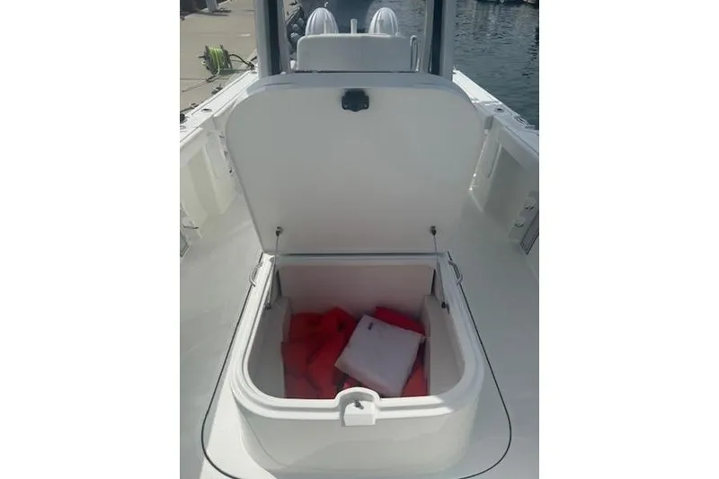 Slide: The Image of Open storage compartment on 2025 Parker 2600 Center Console boat with life jackets inside. - 9