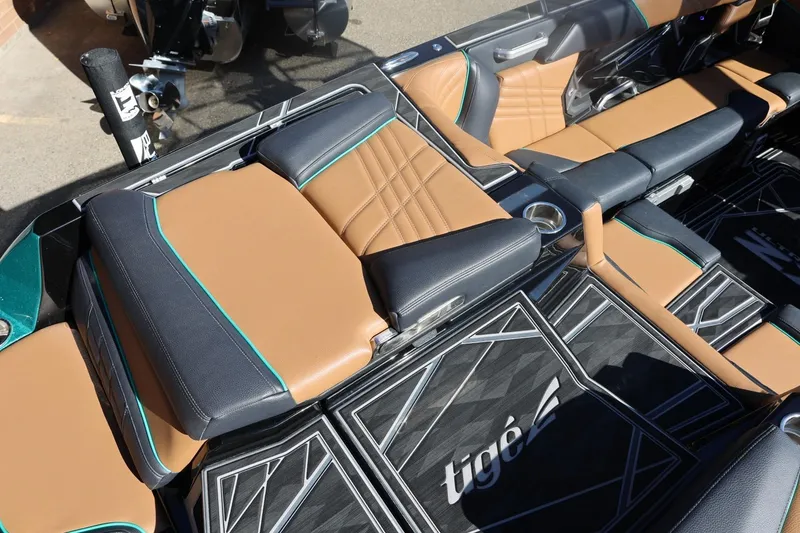 Slide: The Image of 2024 Tigé Ultré 25ZX boat interior with tan and black seating, stylish design. - 16