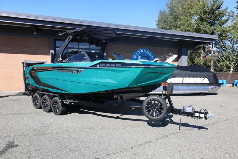 Slide: The Image of 2024 Tigé Ultré 25ZX boat on trailer, parked outdoors near a building. - 2