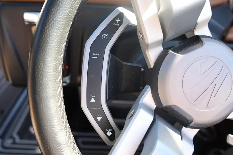 Slide: The Image of Steering wheel controls of 2024 Tigé Ultré 25ZX boat, featuring cruise and surf options. - 38