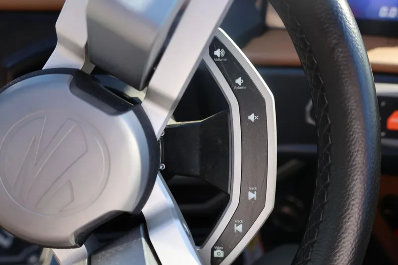 Slide: The Image of Steering wheel controls of 2024 Tigé Ultré 25ZX boat, featuring volume and track buttons. - 39