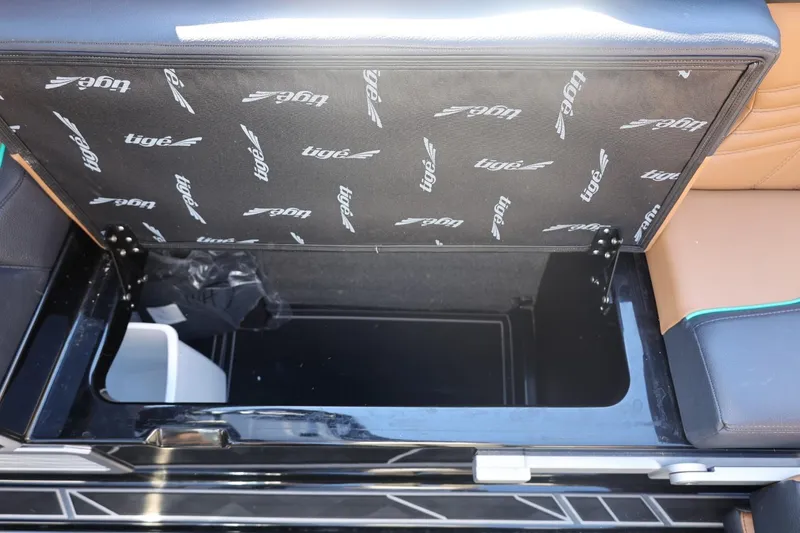 Slide: The Image of 2024 Tigé Ultré 25ZX boat storage compartment with branded interior lining. - 49