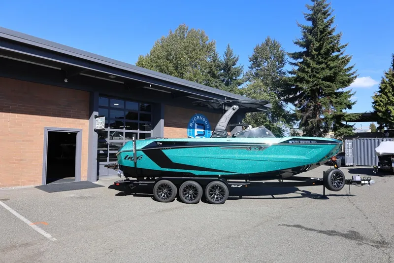 The Image of 2024 Tigé Ultré 25ZX boat on trailer outside dealership, sunny day. - 5