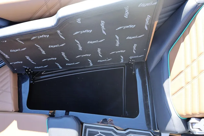 Slide: The Image of 2024 Tigé Ultré 25ZX boat storage compartment with branded interior lining. - 56